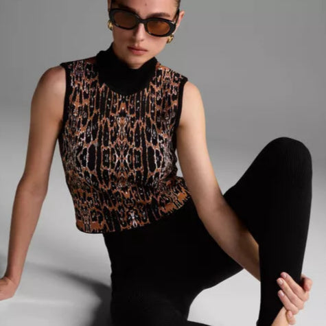 Person wearing a leopard print top and black pants on a gray background