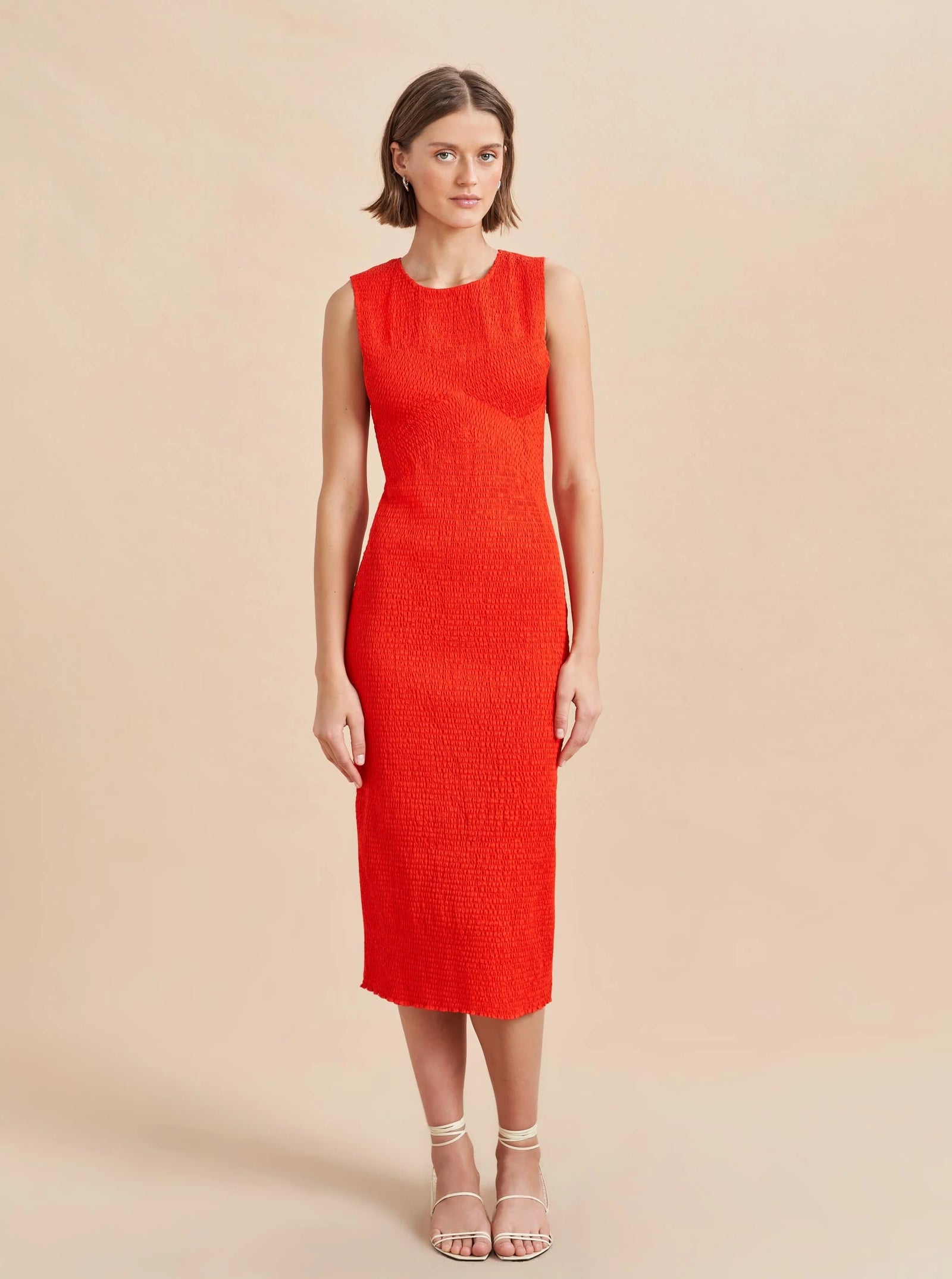 Woman wearing a red dress against a beige background